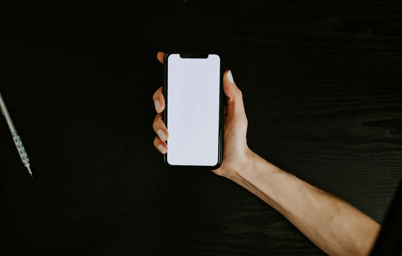 Mão segurando o celular no escuro